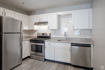 A modern kitchen with stainless steel appliances and white cabinets.